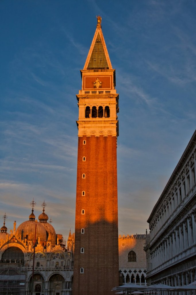 a tall building with a gold roof with St Mark's Campanile in the background